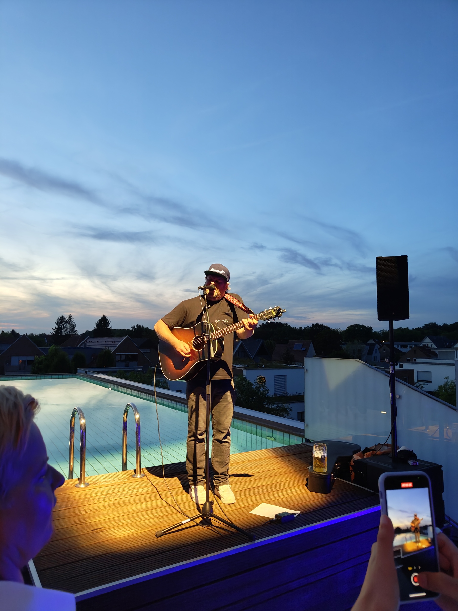 Künstler, der auf einer Dachterrasse spielt, mit Pool im Hintergrund